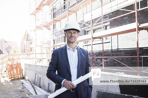 Portrait of confident architect wearing hard hat on construction site