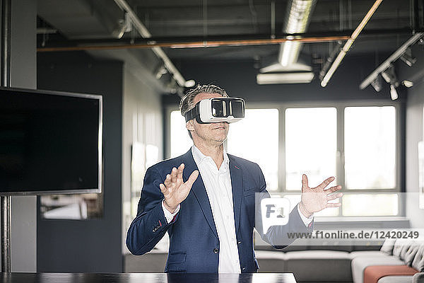 Mature businessman wearing VR glasses