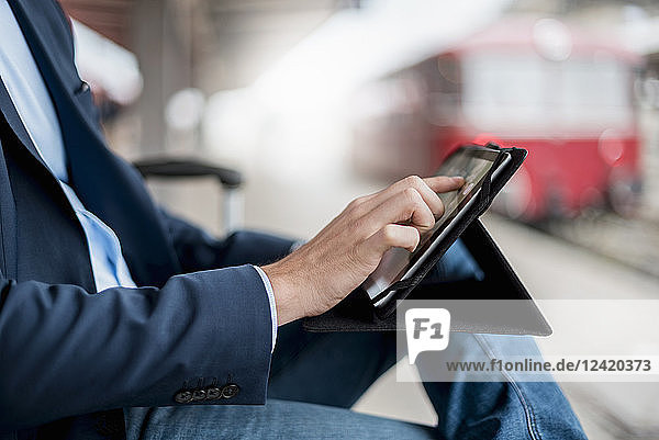 Close-up of businessman at the station using tablet