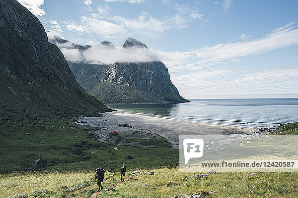 Norway  Lofoten  Moskenesoy  Young men hiking at Kvalvika Beach