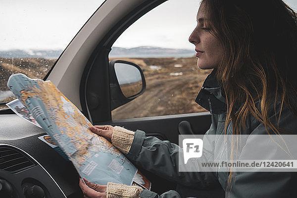 Iceland  young woman in car looking at map