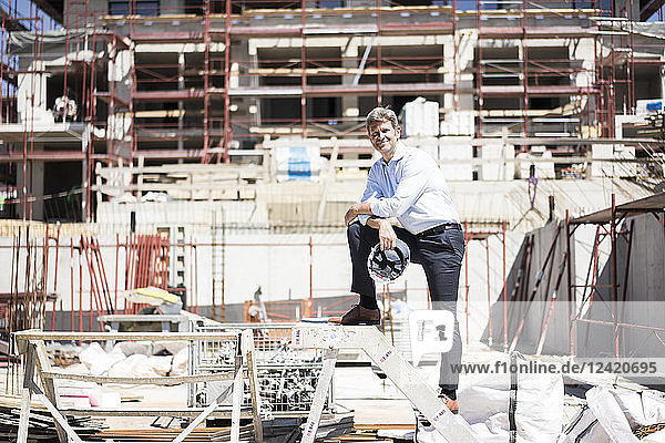 Portrait of smiling man standing on construction site