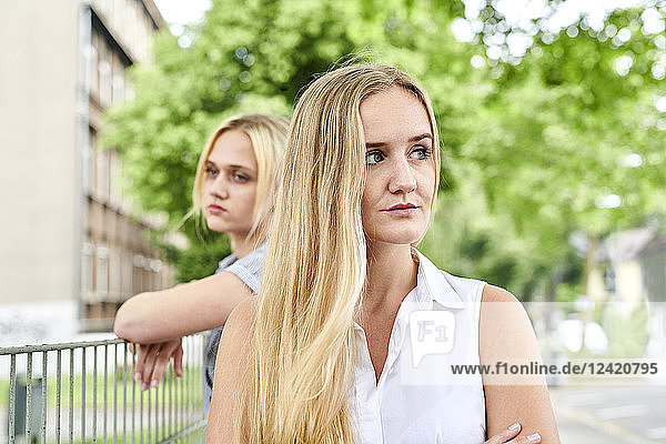 Two discontented young women outdoors