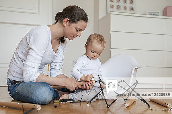 Mother and daughter assembling a chair at home
