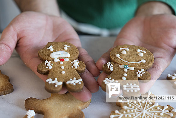 Man's hands holding two different Gingerbread Men  close-up