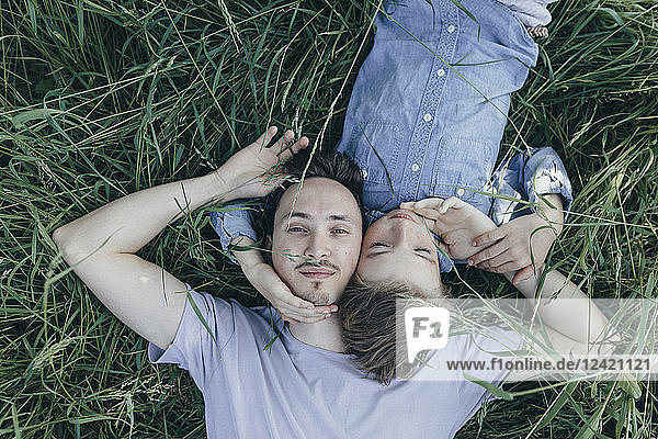 Young man and boy lying in field