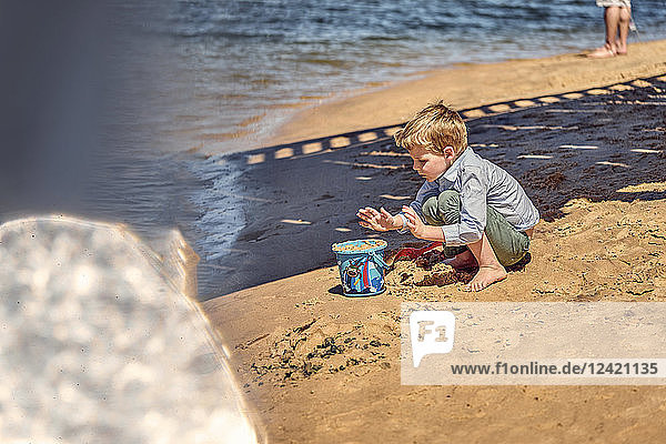 Boy playing in sand at beach