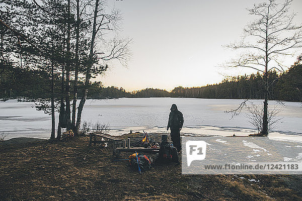 Sweden  Sodermanland  backpacker resting at a remote lake in winter