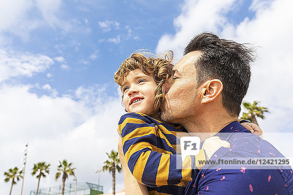 Spain  Barcelona  father kissing son on the beach