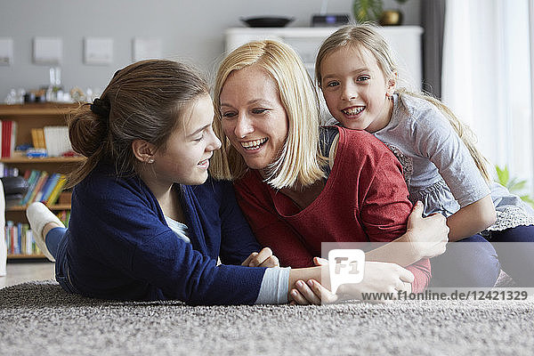 Happy mother and daughters having fun at home