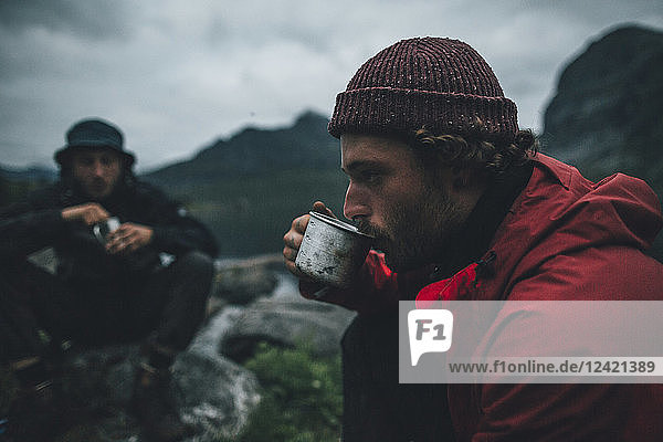 Norway  Lofoten  Moskensoy  Young men having breakfast at Selfjord