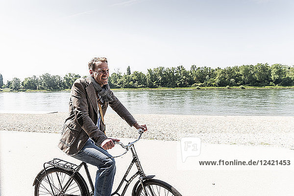 Mature man with bike at Rhine riverbank