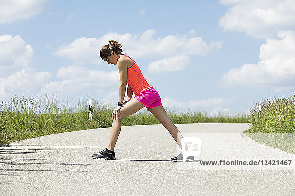 Jogging woman doing stretching exercises on street