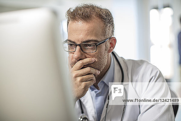 Doctor sitting at desk working on computer