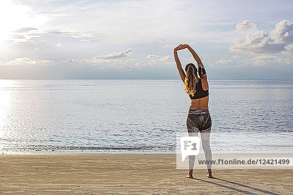 Thailand  Koh Phangan  Sportive woman doing workout on the beach