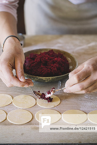 Woman preparing ravioli  beetroot sage filling