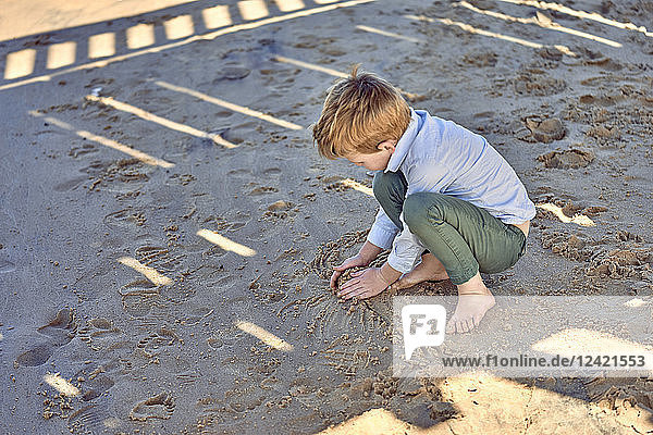 Boy playing in sand at beach