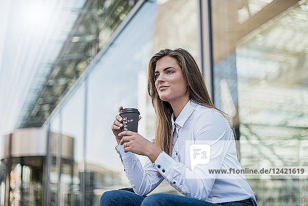 Portrait of young businesswoman with coffee to go