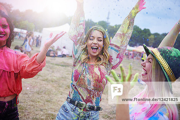 Friends dancing during music festival  colour powder