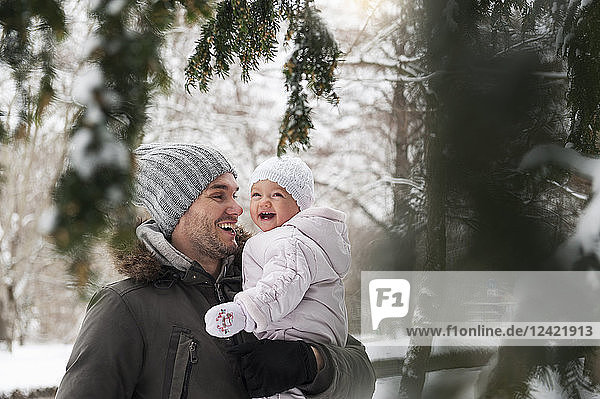 Portrait of happy father with laughing baby girl in winter