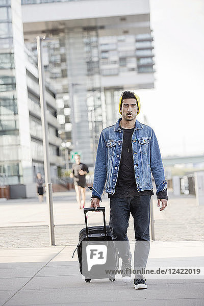 Germany  Cologne  portrait of young man pulling trolley
