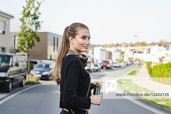 Smiling sportive young woman on a street in the city