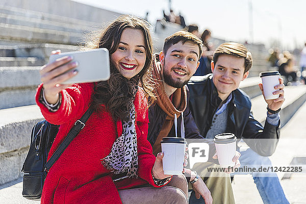 Russia  Moscow  group of friends taking a selfie and showing their cups of coffee