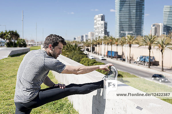 Sportive man stretching in urban area