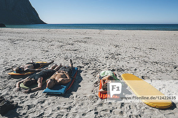 Norway  Lofoten  Moskenesoy  Friends sunbathing on Kvalvika Beach