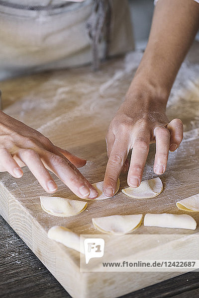 Woman preparing ravioli on pastry board