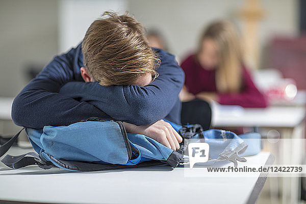 Teenage boy sleeping in class