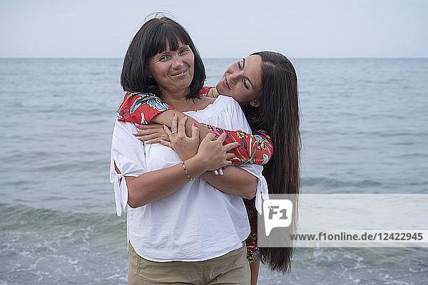 Greece  portrait of happy mother with her adult daughter in front of the sea