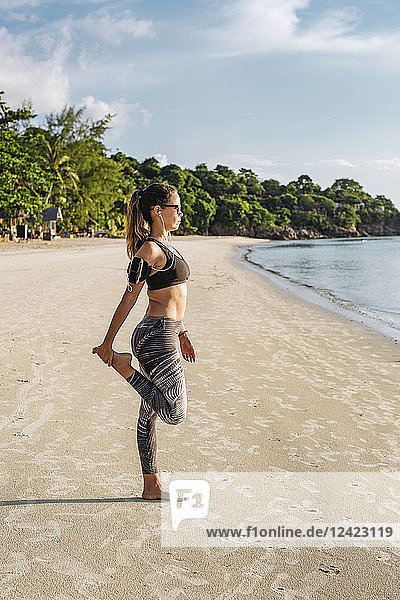 Thailand  Koh Phangan  Sportive woman doing workout on the beach