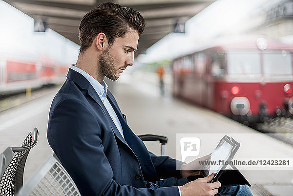 Businessman at the station using tablet