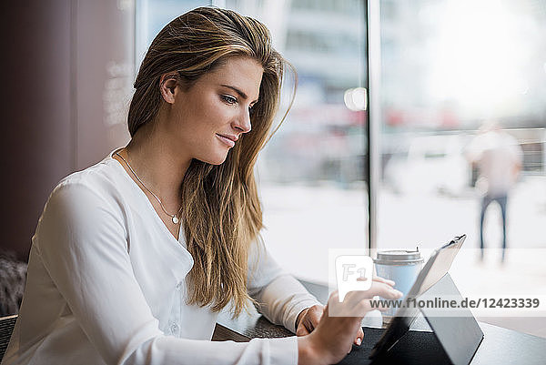 Young businesswoman in a cafe using tablet