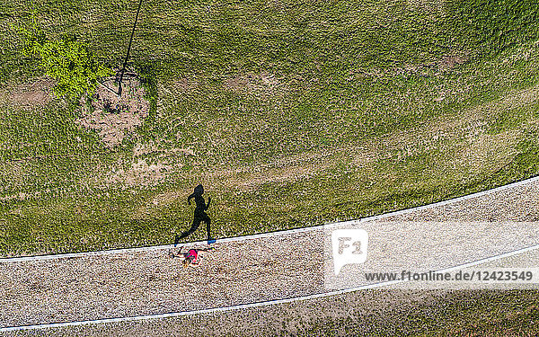 Aerial view of female jogger on woodchip trail