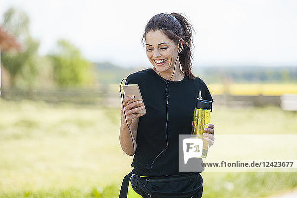 Sportive woman using smartphone during cooling break