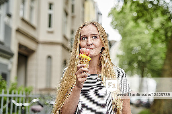 Young woman enjoying an ice cream cone in the city