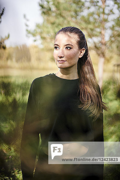 Sportive young woman in nature looking sideways