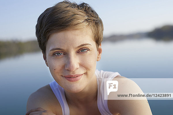 Portrait of smiling woman in front of lake