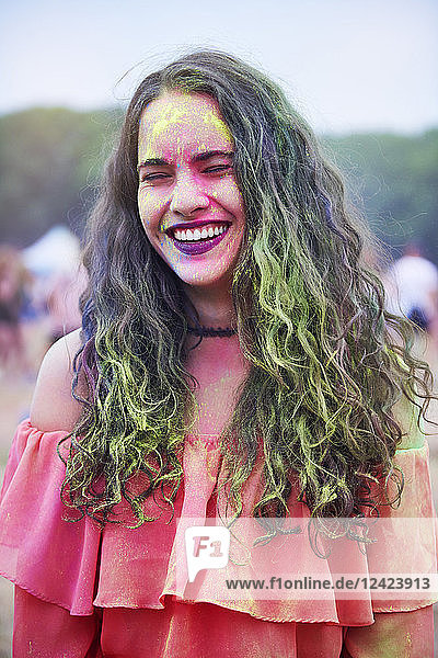 Portrait of young woman with colour powder at music festival