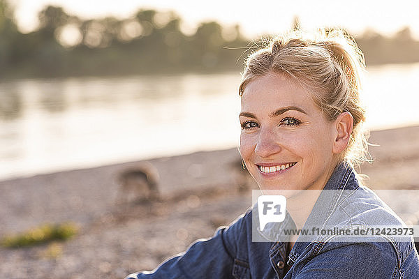 Portrait of blond woman at riverside in the evening