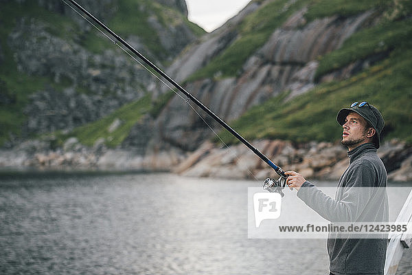 Norway  Lofoten  Moskenesoy  Young man fishing at Krokvatnet