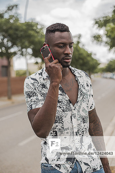 Young man in the city  standing in the street  talking on the phone