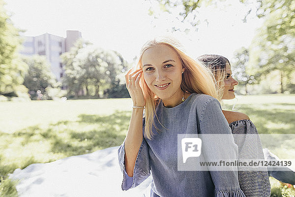 Portrait of two smiling young women relaxing in a park