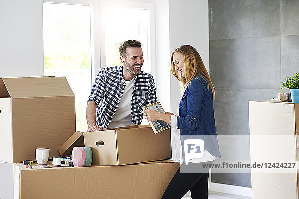 Couple moving into new flat packing cardboard boxes