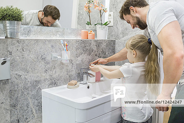 Fahtehr helping his little daughter washing her hands