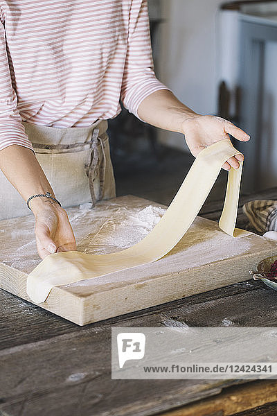 Woman preparing homemade pasta  taking dough