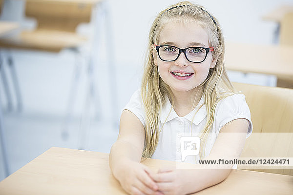 Portrait of smiling schoolgirl in class