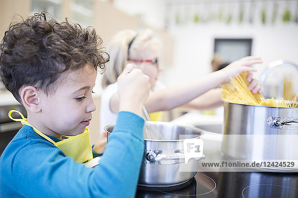 Pupils preparing pasta in cooking class